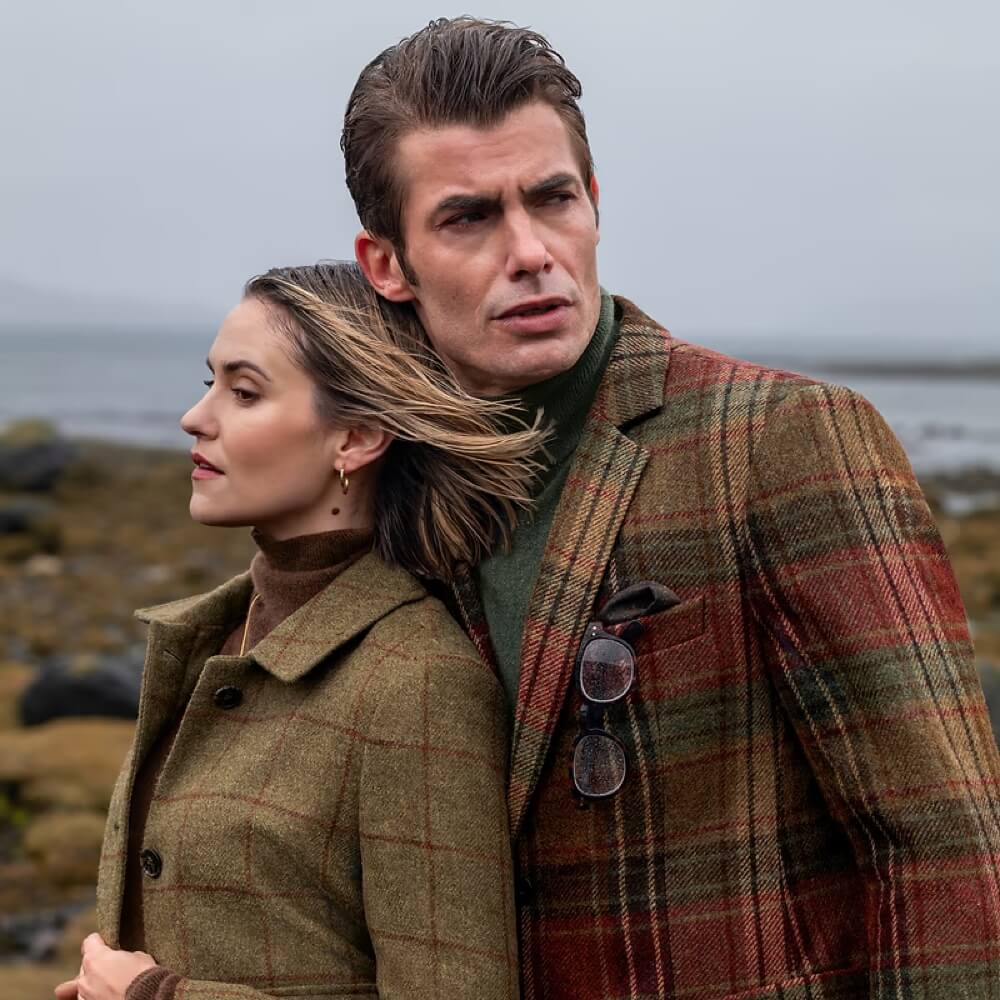 Couple in tweed and waxed country jackets outdoors
